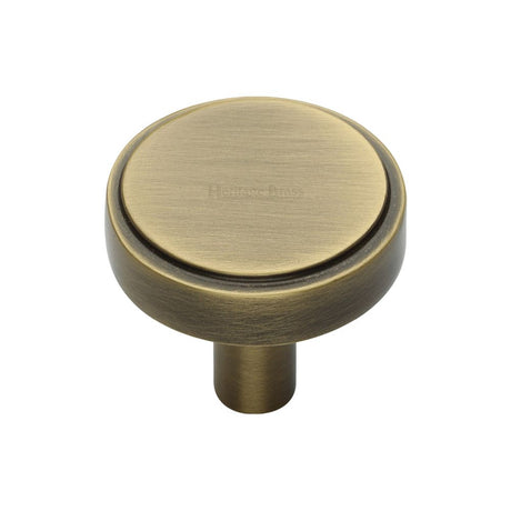 This is an image of a Heritage Brass - Cabinet Knob Stepped Disc Design 32mm Antique Brass Finish, c3952-32-at that is available to order from T.H Wiggans Ironmongery in Kendal.