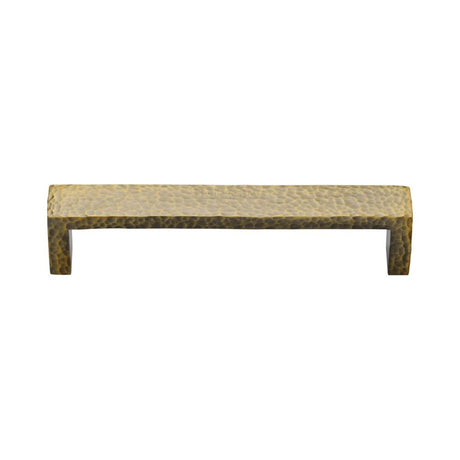 This is an image of a Heritage Brass - Cabinet Pull Hammered Wide Metro Design 128mm CTC Antique Brass Fi, c4525-128-at that is available to order from T.H Wiggans Ironmongery in Kendal.