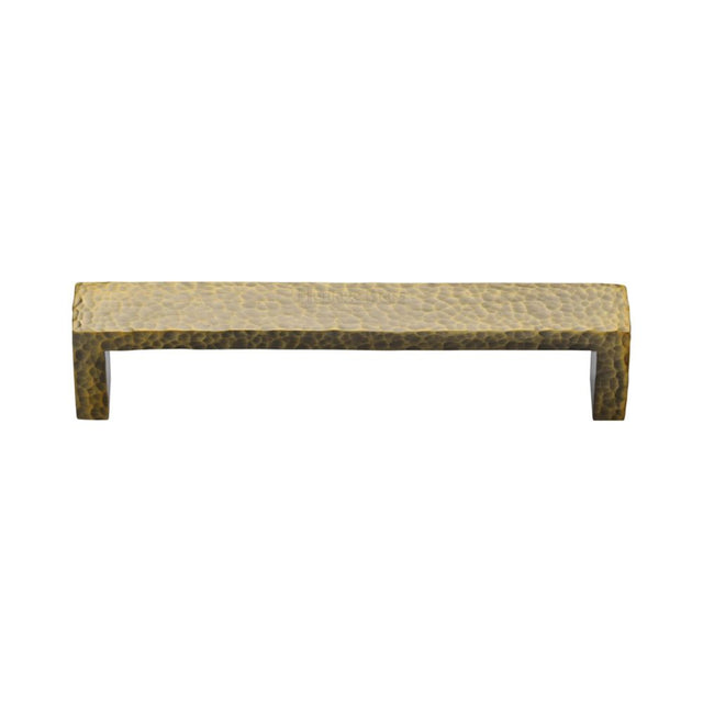 This is an image of a Heritage Brass - Cabinet Pull Hammered Wide Metro Design 128mm CTC Antique Brass Fi, c4525-128-at that is available to order from T.H Wiggans Ironmongery in Kendal.