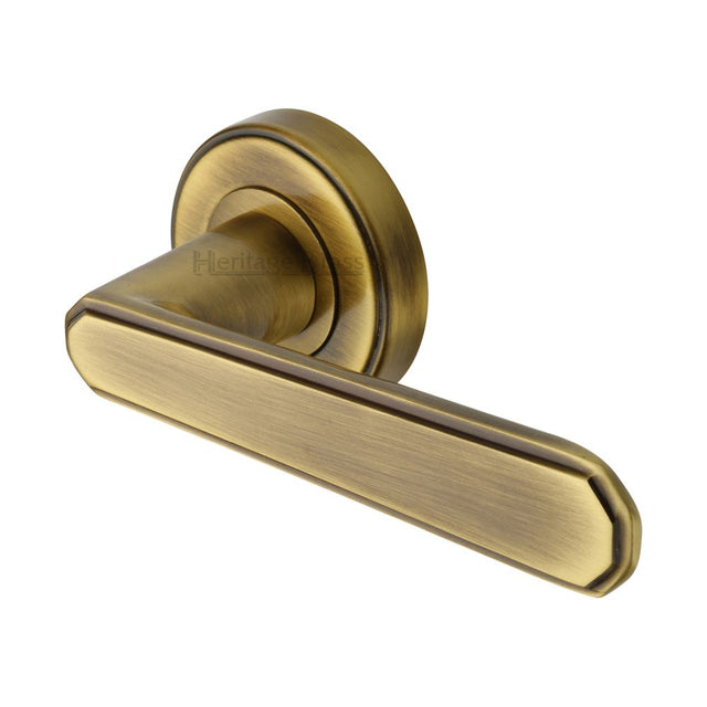 This is an image of a Heritage Brass - Door Handle Lever Latch on Round Rose Century Design Antique Brass, cen1924-at that is available to order from T.H Wiggans Ironmongery in Kendal.