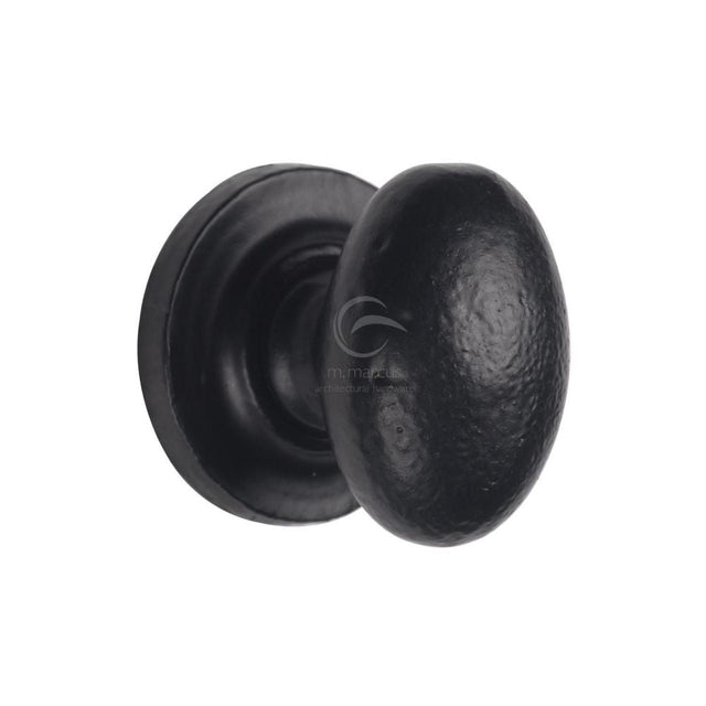 This is an image of a M.Marcus - Black Iron Rustic Cabinet Knob on Round Plate Oval Design 32mm, fb179-32 that is available to order from T.H Wiggans Ironmongery in Kendal.