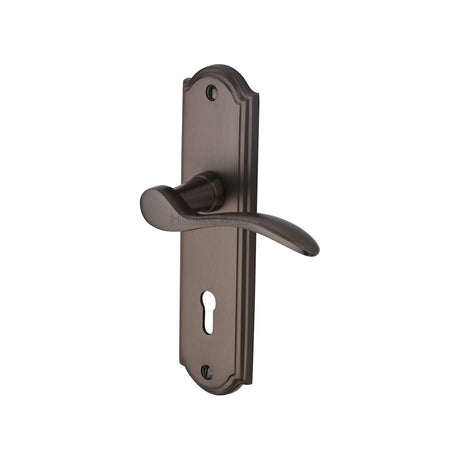 This is an image of a Heritage Brass - Door Handle Lever Lock Howard Design Matt Bronze Finish, how1300-mb that is available to order from T.H Wiggans Ironmongery in Kendal.