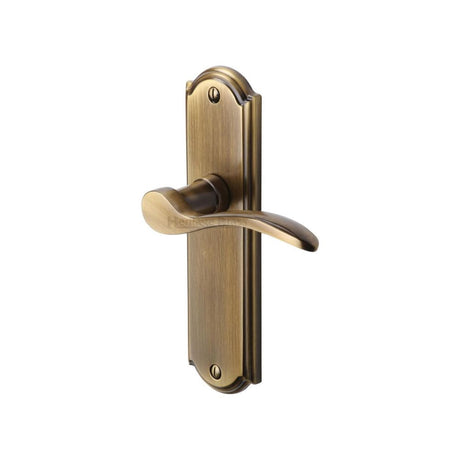 This is an image of a Heritage Brass - Door Handle Lever Latch Howard Design Antique Brass Finish, how1310-at that is available to order from T.H Wiggans Ironmongery in Kendal.