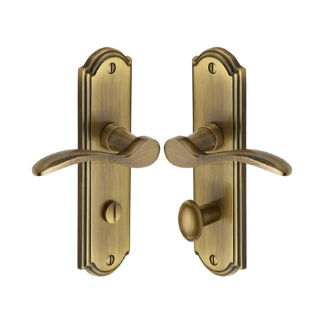 This is an image of a Heritage Brass - Door Handle for Bathroom Howard Design Antique Brass Finish, how1330-at that is available to order from T.H Wiggans Ironmongery in Kendal.