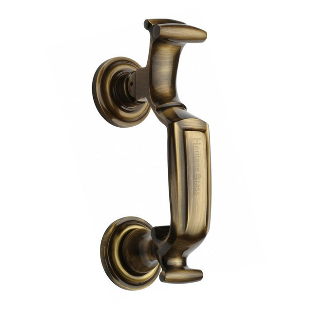 This is an image of a Heritage Brass - Doctor Knocker Antique Brass Finish, k1300-at that is available to order from T.H Wiggans Ironmongery in Kendal.