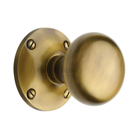 This is an image of a Heritage Brass - Mortice Knob on Rose Kensington Design Antique Brass Finish, ken980-at that is available to order from T.H Wiggans Ironmongery in Kendal.