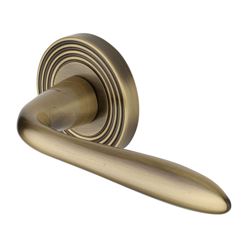 This is an image of a Heritage Brass - Door Handle Lever Latch on Round Rose Sutton Reeded Design Antique, rr1752-at that is available to order from T.H Wiggans Ironmongery in Kendal.
