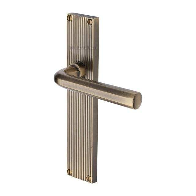 This is an image of a Heritage Brass - Octave Reeded Lever Latch Antique Brass finish, rr3710-at that is available to order from T.H Wiggans Ironmongery in Kendal.