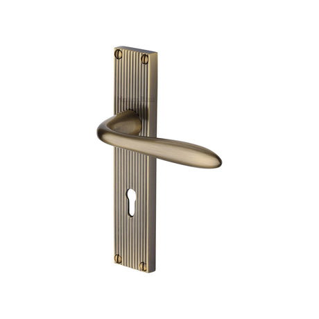 This is an image of a Heritage Brass - Sutton Reeded Lever Lock Antique Brass finish, rr5000-at that is available to order from T.H Wiggans Ironmongery in Kendal.