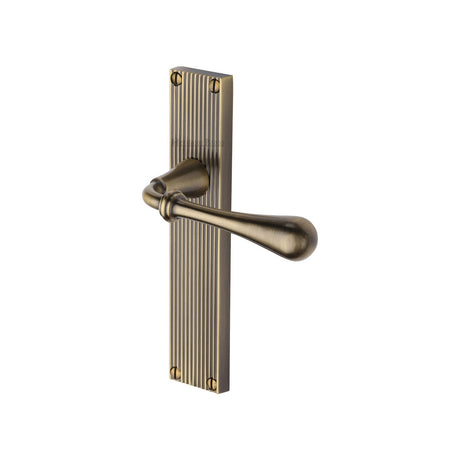 This is an image of a Heritage Brass - Roma Reeded Lever Latch Antique Brass finish, rr6010-at that is available to order from T.H Wiggans Ironmongery in Kendal.