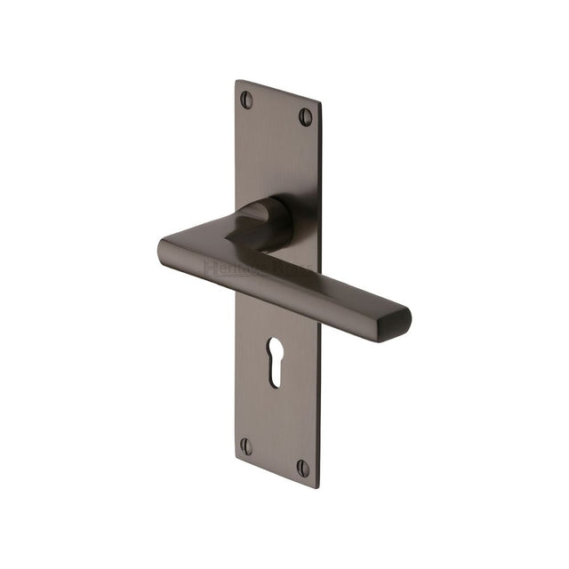 This is an image of a Heritage Brass - Door Handle Lever Lock Trident Design Matt Bronze Finish, tri1300-mb that is available to order from T.H Wiggans Ironmongery in Kendal.