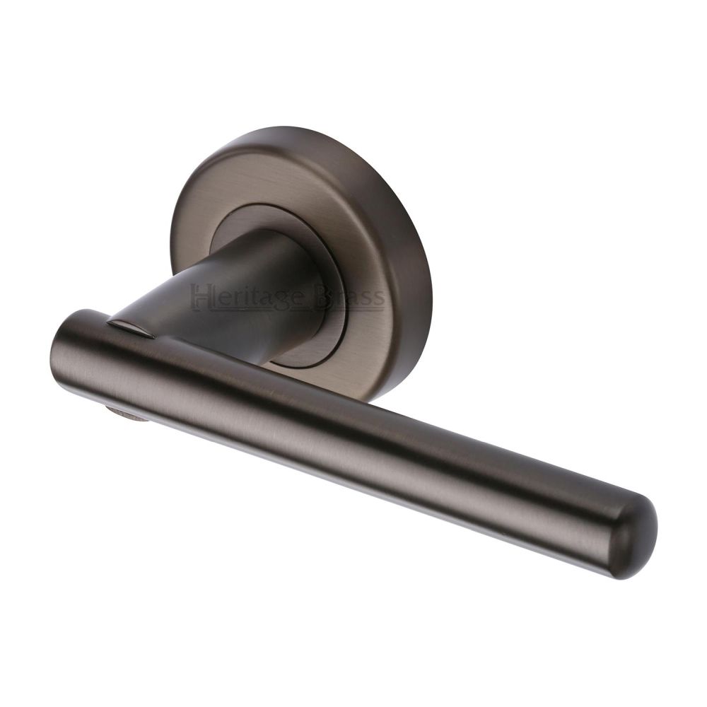 This is an image of a Heritage Brass - Door Handle Lever on Rose Challenger Design Matt Bronze Finish, v1001-mb that is available to order from T.H Wiggans Ironmongery in Kendal.