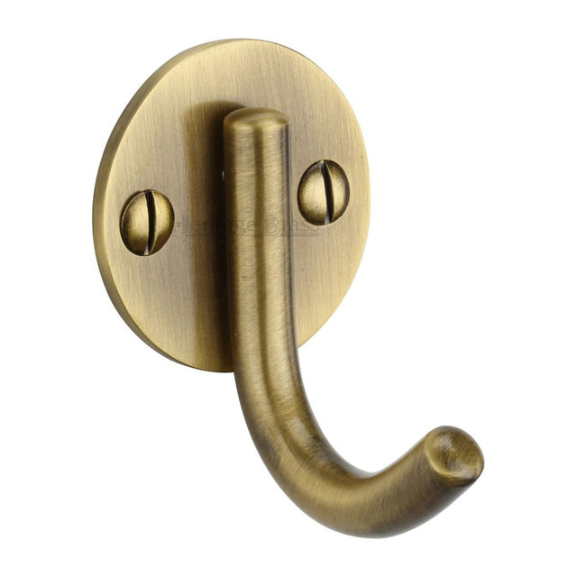 This is an image of a Heritage Brass - Single Robe Hook Antique Brass Finish, v1064-at that is available to order from T.H Wiggans Ironmongery in Kendal.