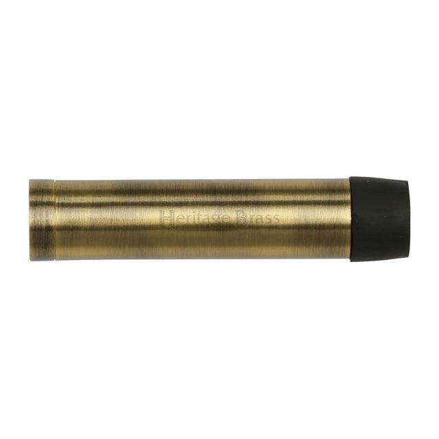 This is an image of a Heritage Brass - Cylindrical Door Stop Without Rose 64mm Antique Brass Finish, v1081-64-at that is available to order from T.H Wiggans Ironmongery in Kendal.