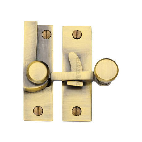 This is an image of a Heritage Brass - Sash Fastener Antique Brass Finish, v1100-at that is available to order from T.H Wiggans Ironmongery in Kendal.