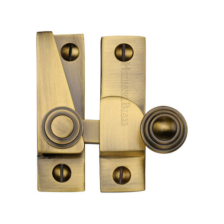 This is an image of a Heritage Brass - Sash Fastener Antique Brass Finish, v1104-at that is available to order from T.H Wiggans Ironmongery in Kendal.