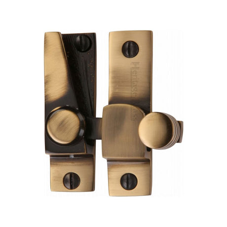 This is an image of a Heritage Brass - Sash Fastener Antique Brass Finish, v1105-at that is available to order from T.H Wiggans Ironmongery in Kendal.
