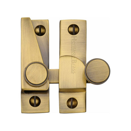 This is an image of a Heritage Brass - Sash Fastener Antique Brass Finish, v1106-at that is available to order from T.H Wiggans Ironmongery in Kendal.