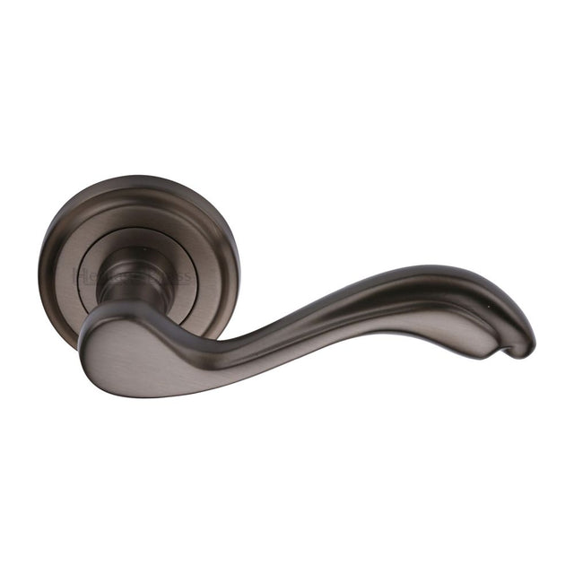 This is an image of a Heritage Brass - Door Handle Lever Latch on Round Rose Lisboa Design Matt Bronze, v1601-mb that is available to order from T.H Wiggans Ironmongery in Kendal.