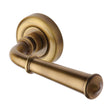 This is an image of a Heritage Brass - Door Handle Lever Latch on Round Rose Colonial Design Antique Bras, v1932-at that is available to order from T.H Wiggans Ironmongery in Kendal.