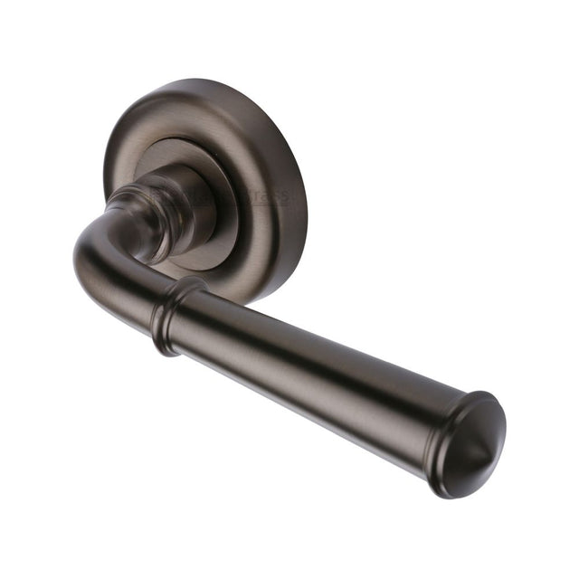 This is an image of a Heritage Brass - Door Handle Lever Latch on Round Rose Colonial Design Matt Bron, v1932-mb that is available to order from T.H Wiggans Ironmongery in Kendal.