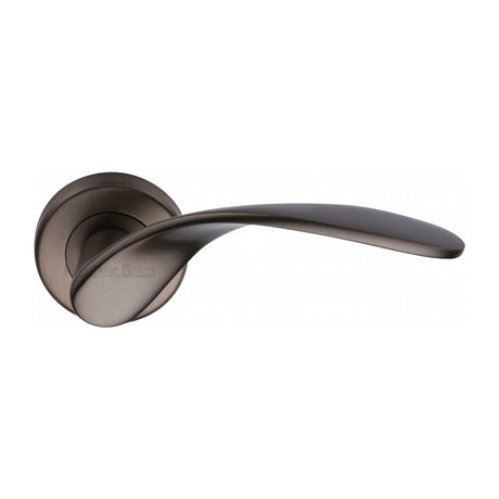 This is an image of a Heritage Brass - Door Handle Lever Latch on Round Rose Volo Design Matt Bronze finish, v1950-mb that is available to order from T.H Wiggans Ironmongery in Kendal.