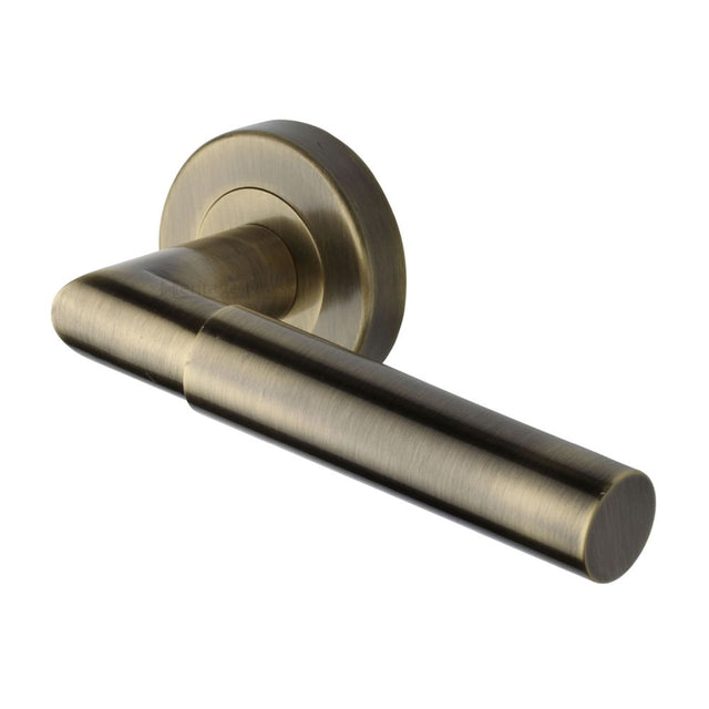 This is an image of a Heritage Brass - Door Handle Lever Latch on Round Rose Bauhaus Mitre Design Antique, v2270-at that is available to order from T.H Wiggans Ironmongery in Kendal.