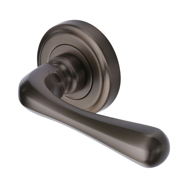 This is an image of a Heritage Brass - Door Handle Lever Latch on Round Rose Charlbury Design Matt Bro, v3020-mb that is available to order from T.H Wiggans Ironmongery in Kendal.