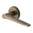 This is an image of a Heritage Brass - Door Handle Lever on Rose Gio Design Antique Brass Finish, v4189-at that is available to order from T.H Wiggans Ironmongery in Kendal.
