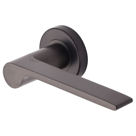 This is an image of a Heritage Brass - Door Handle Lever Latch on Round Rose Julia Design Matt Bronze, v4190-mb that is available to order from T.H Wiggans Ironmongery in Kendal.