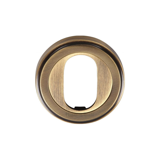 This is an image of a Heritage Brass - Oval Profile Cylinder Escutcheon Antique Brass Finish, v5010-at that is available to order from T.H Wiggans Ironmongery in Kendal.