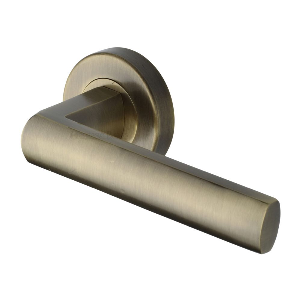 This is an image of a Heritage Brass - Door Handle Lever Latch on Round Rose Poseidon Design Antique Bras, v6230-at that is available to order from T.H Wiggans Ironmongery in Kendal.