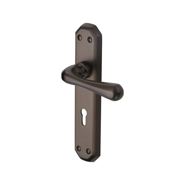 This is an image of a Heritage Brass - Door Handle Lever Lock Charlbury Design Matt Bronze Finish, v7050-mb that is available to order from T.H Wiggans Ironmongery in Kendal.