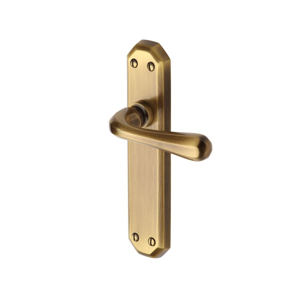 This is an image of a Heritage Brass - Door Handle Lever Latch Charlbury Design Antique Brass Finish, v7060-at that is available to order from T.H Wiggans Ironmongery in Kendal.