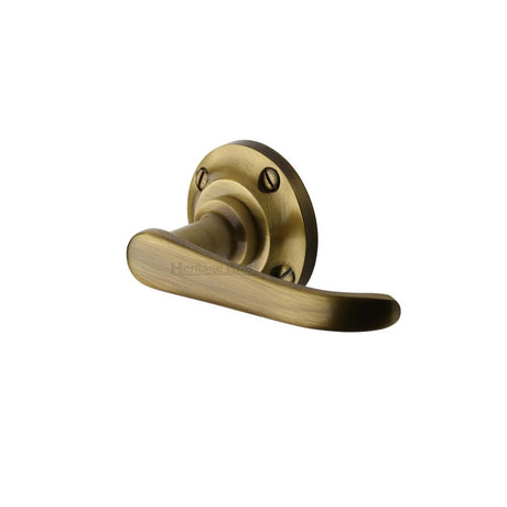 This is an image of a Heritage Brass - Door Handle Lever Latch on Round Rose Windsor Design Antique Brass, v720-at that is available to order from T.H Wiggans Ironmongery in Kendal.