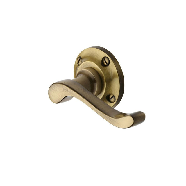 This is an image of a Heritage Brass - Door Handle Lever Latch on 57mm Round Rose Bedford Design Antique, v820-at that is available to order from T.H Wiggans Ironmongery in Kendal.