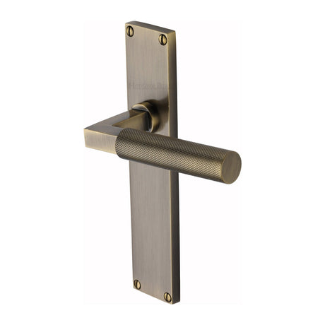 This is an image of a Heritage Brass - Bauhaus Knurled Lever Latch Door Handle on 200mm Plate Antique Brass finish, vt9310-at that is available to order from T.H Wiggans Ironmongery in Kendal.