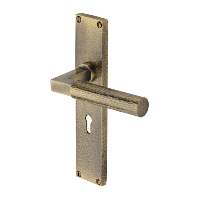 This is an image of a Heritage Brass - Bauhaus Hammered Lever Lock Door Handle on 200mm Plate Antique Brass finish, vth4300-at that is available to order from T.H Wiggans Ironmongery in Kendal.