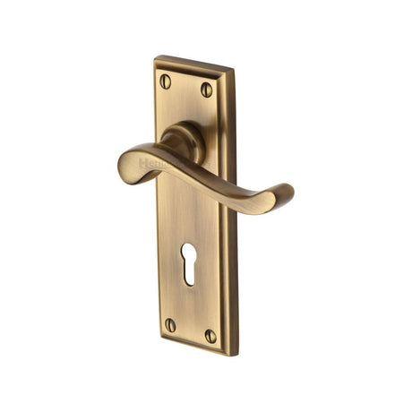 This is an image of a Heritage Brass - Door Handle Lever Lock Edwardian Design Antique Brass Finish, w3200-at that is available to order from T.H Wiggans Ironmongery in Kendal.