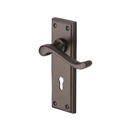 This is an image of a Heritage Brass - Door Handle Lever Lock Edwardian Design Matt Bronze Finish, w3200-mb that is available to order from T.H Wiggans Ironmongery in Kendal.