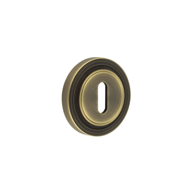 This is an image showing the Frelan - Burlington Standard Keyway Escutcheons Reeded Rose Antique Brass available to order from T.H. Wiggans Ironmongery in Kendal