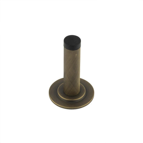 This is an image showing the Frelan - Burlington Knurled Wall Mounted Door Stop Stepped Rose Antique Brass available to order from T.H. Wiggans Ironmongery in Kendal