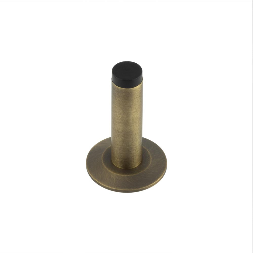 This is an image showing the Frelan - Burlington Plain Wall Mounted Door Stops Chamfered Rose Antique Brass available to order from T.H. Wiggans Ironmongery in Kendal