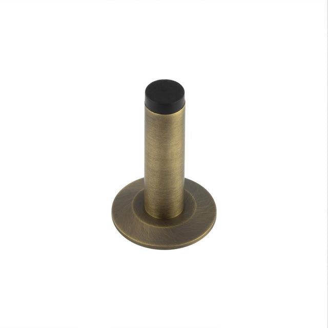 This is an image showing the Frelan - Burlington Plain Wall Mounted Door Stops Chamfered Rose Antique Brass available to order from T.H. Wiggans Ironmongery in Kendal