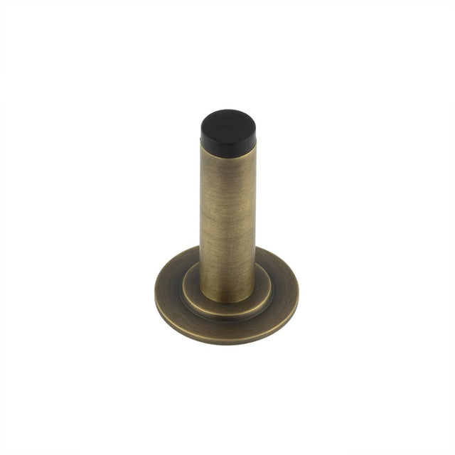 This is an image showing the Frelan - Burlington Plain Wall Mounted Door Stops Stepped Rose Antique Brass available to order from T.H. Wiggans Ironmongery in Kendal