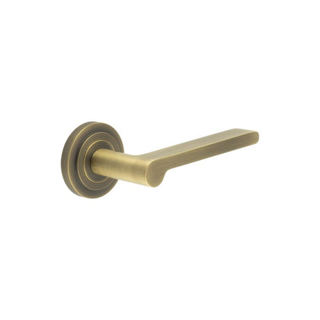 This is an image showing the Frelan - Fitzrovia Door Handles Stepped Rose Antique Brass available to order from T.H. Wiggans Ironmongery in Kendal