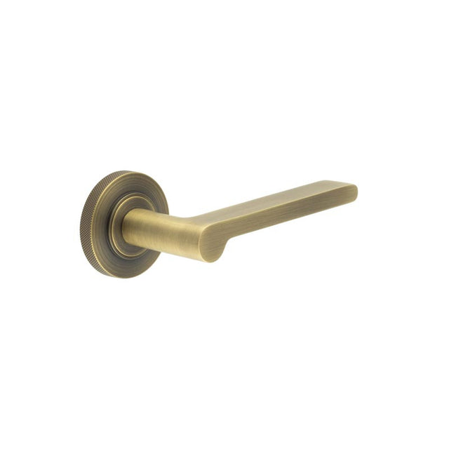 This is an image showing the Frelan - Fitzrovia Door Handles Knurled Rose Antique Brass available to order from T.H. Wiggans Ironmongery in Kendal