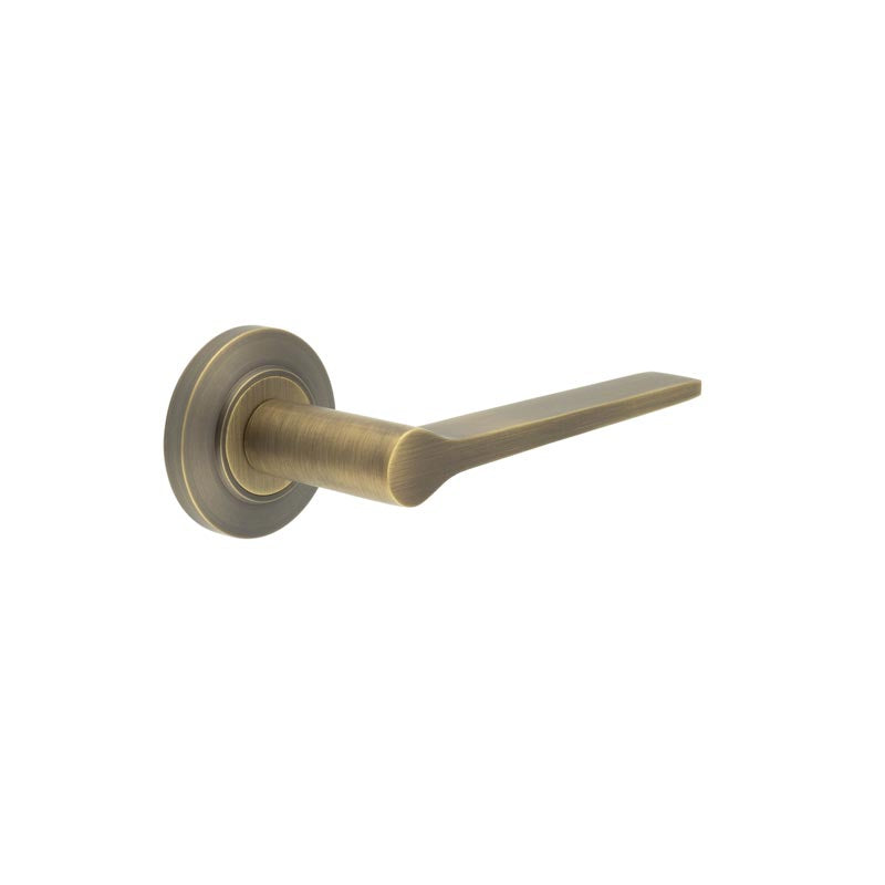 This is an image showing the Frelan - Knightsbridge Door Handle on Chamfered Rose Antique Brass available to order from T.H. Wiggans Ironmongery in Kendal