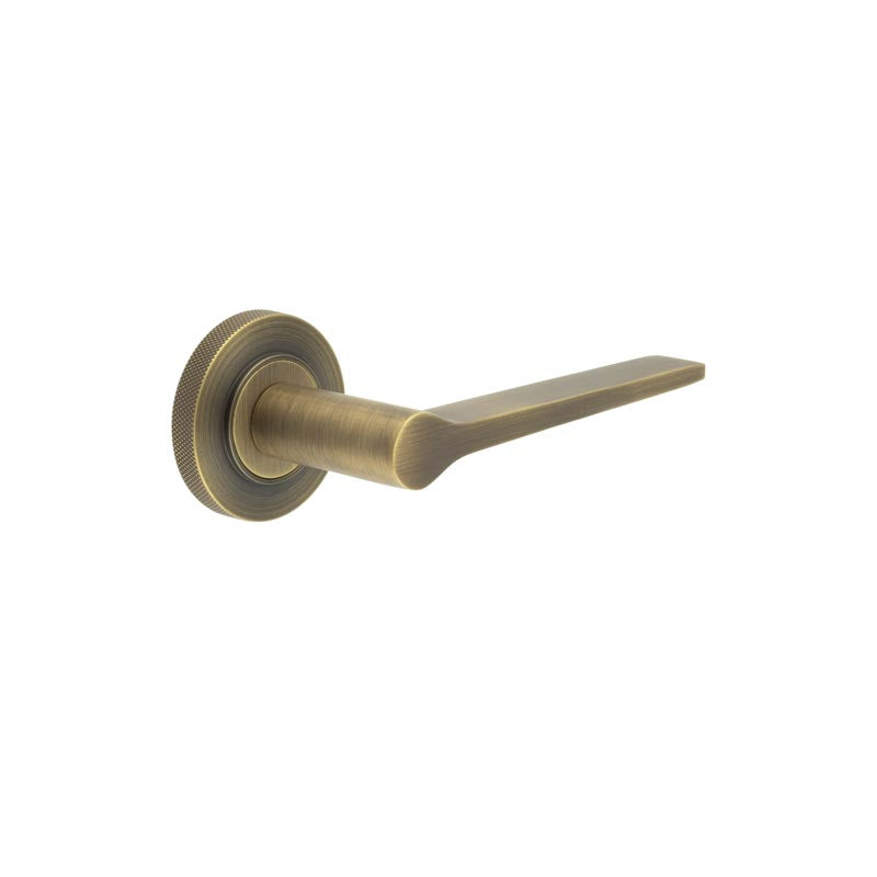 This is an image showing the Frelan - Knightsbridge Door Handle on Knurled Rose Antique Brass available to order from T.H. Wiggans Ironmongery in Kendal