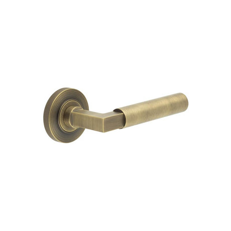 This is an image showing the Frelan - Westminster Door Handle on Knurled Rose Antique Brass available to order from T.H. Wiggans Ironmongery in Kendal